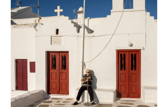 14 June 2023, Greece, Mykonos: An elderly man rest beneath a church in Mykonos main town.